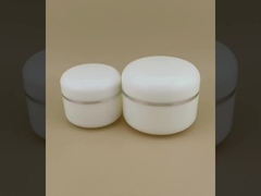 Okrągły, biały plastikowy słoiczek na krem z zaokrąglonymi krawędziami i srebrnym obrzeżem do balsamu dla kobiet